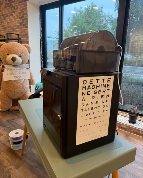 La machine 3D avec l'affiche « Cette machine ne sert à rien sans le talent de l'opticien »